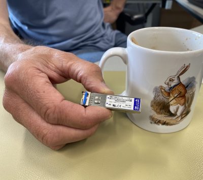 coffee cup with a rabbit on it and a hand holding a small electronic device